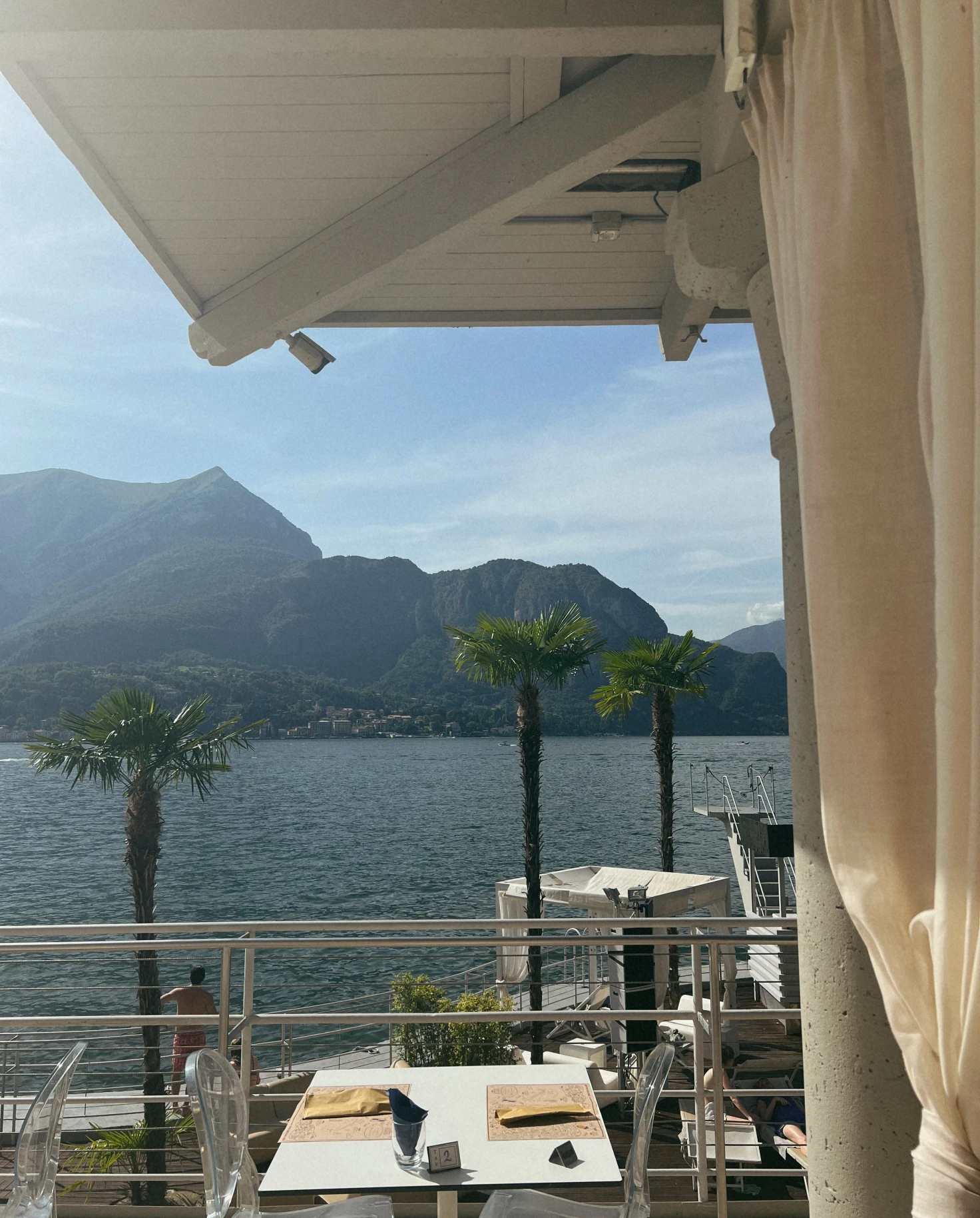 Seaside outdoor patio of Lido restaurant in Lake Como, Italy on a sunny day.