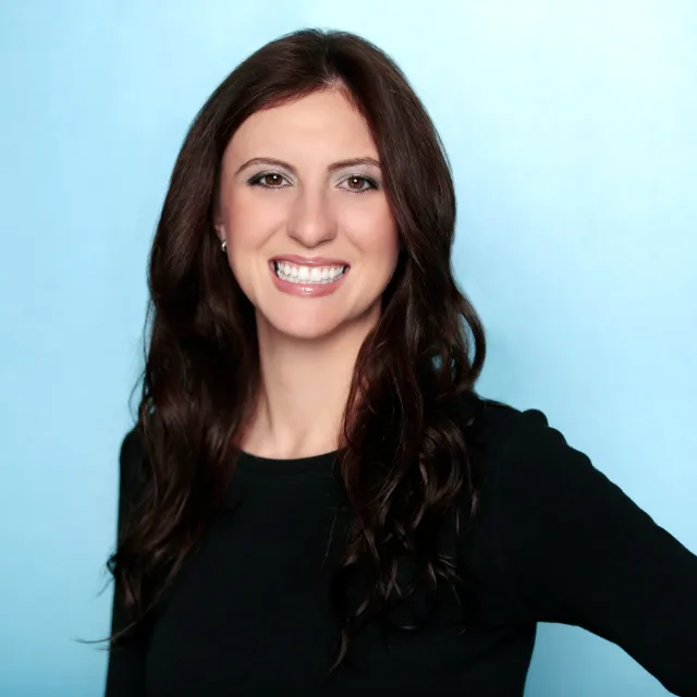 travel advisor jaclyn churchill wears a black long sleeve top in front of a blue background