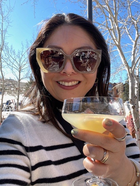 A selfie of a woman holding a drink outside in Aspen Colorado, celebrating New Year's.