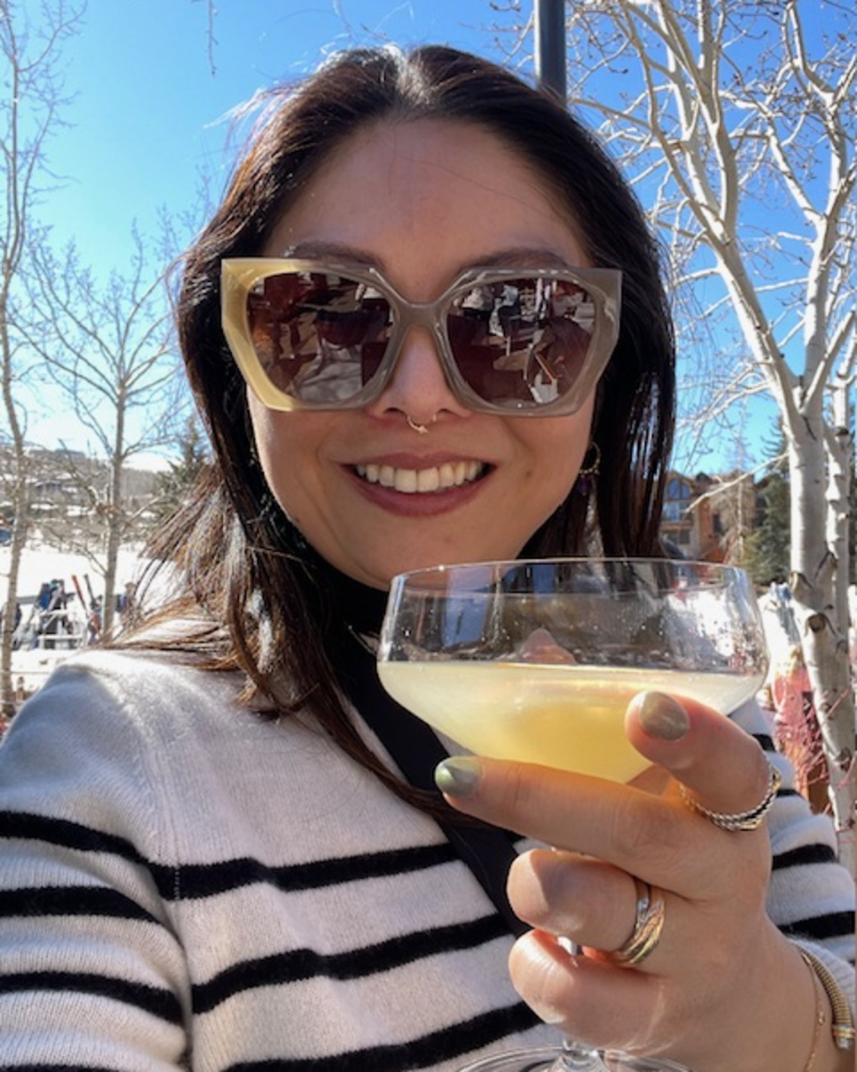 A selfie of a woman holding a drink outside in Aspen Colorado, celebrating New Year's.