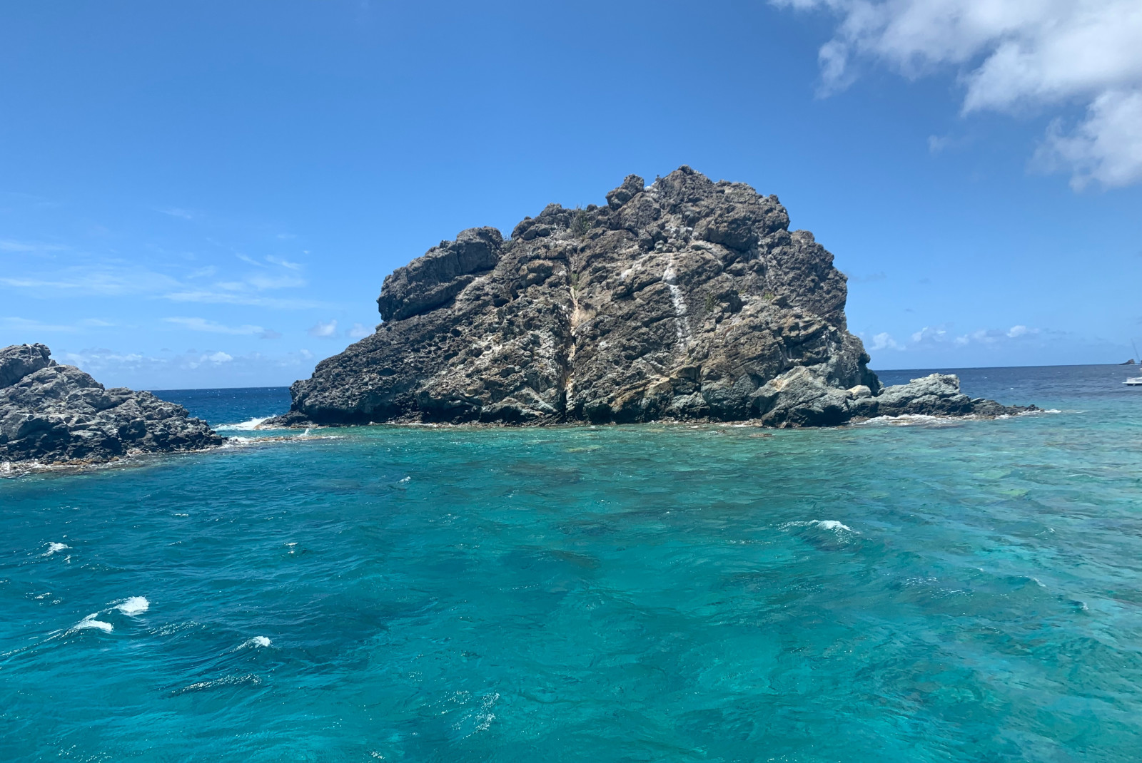 Rock in the middle of blue ocean waters 