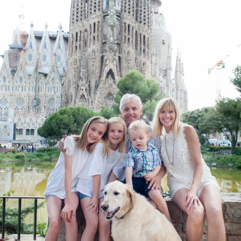 A view of Jill, a man, three kids and a dog posing in front of a popular tourist attraction in Barcelona, Spain. 