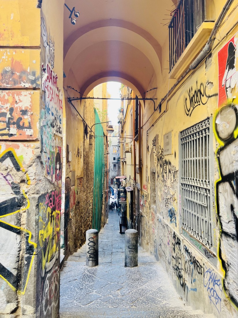 An outdoor hallways with graffitied walls