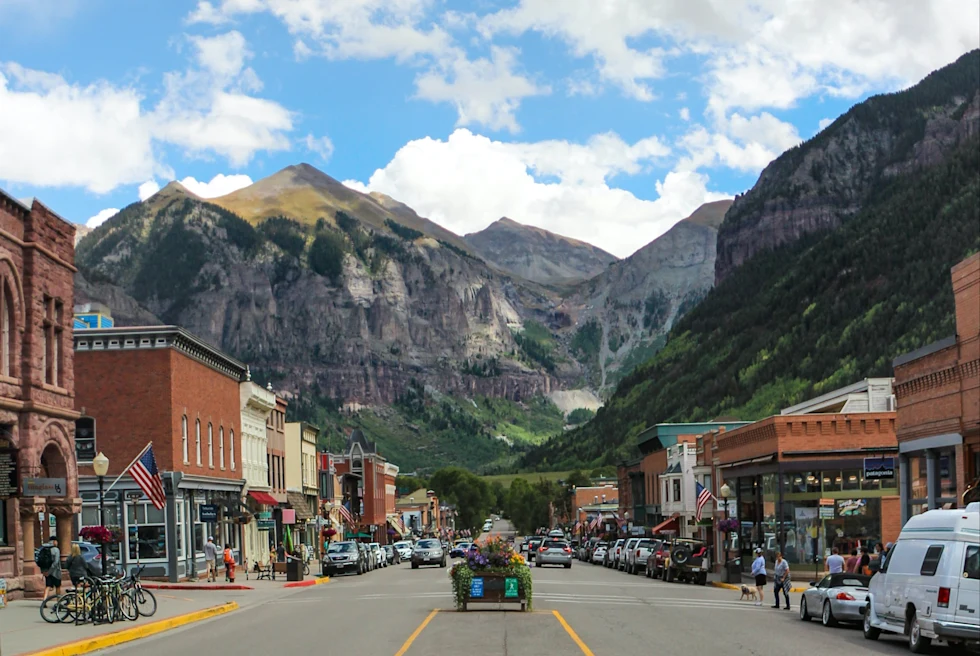 downtown street with shops and mountains in the background