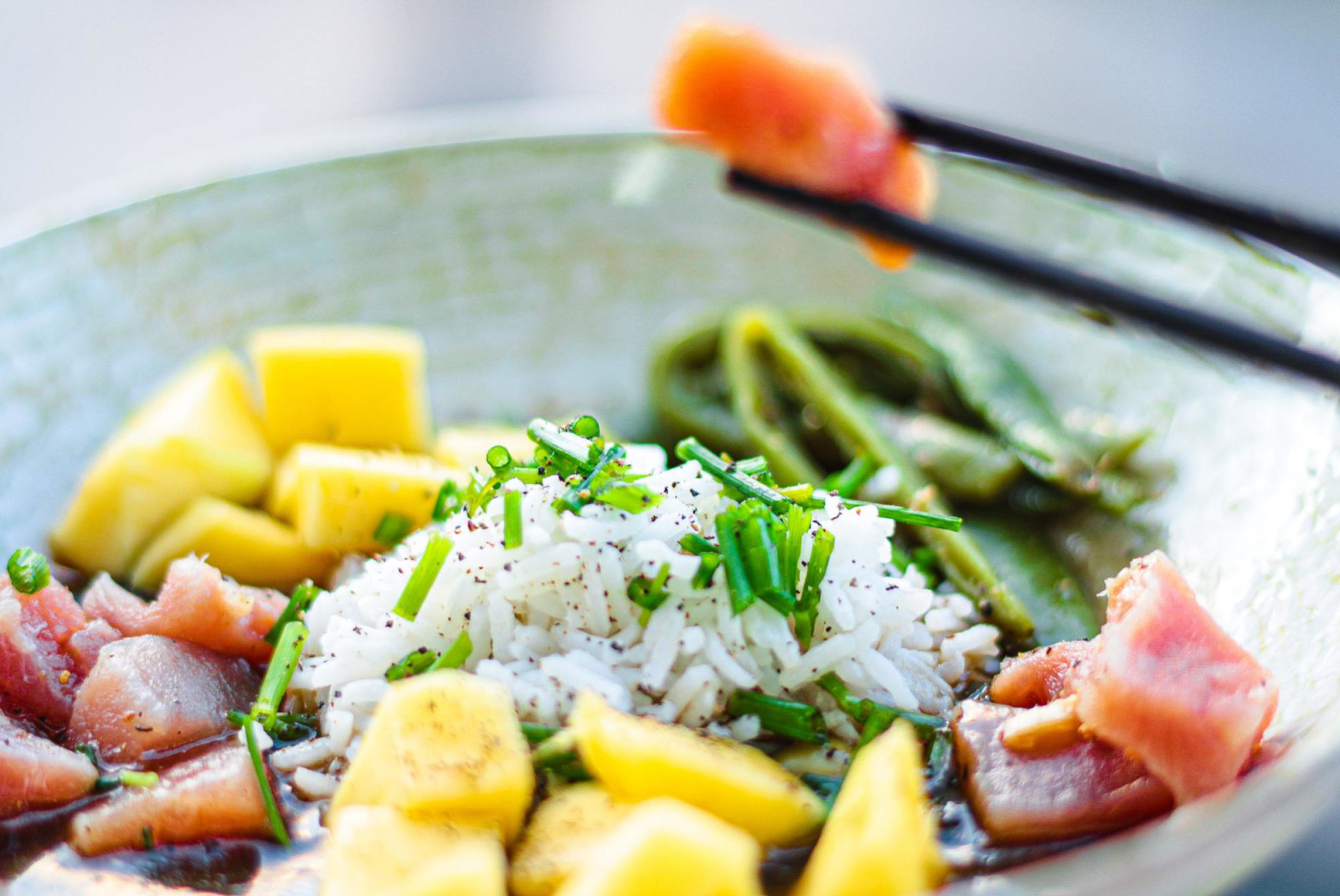 Poke bowl with salmon, rice, chives and pineapple. 