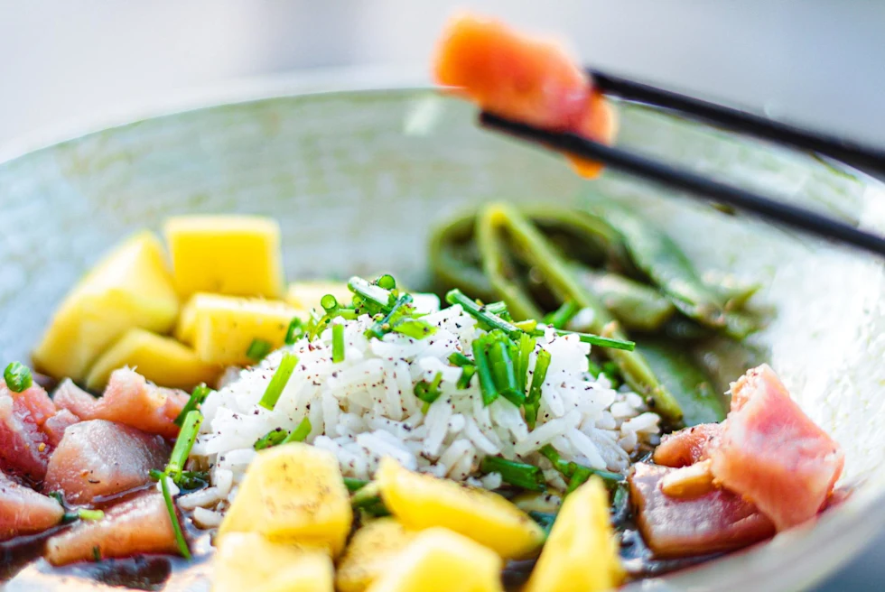 Poke bowl with salmon, rice, chives and pineapple.