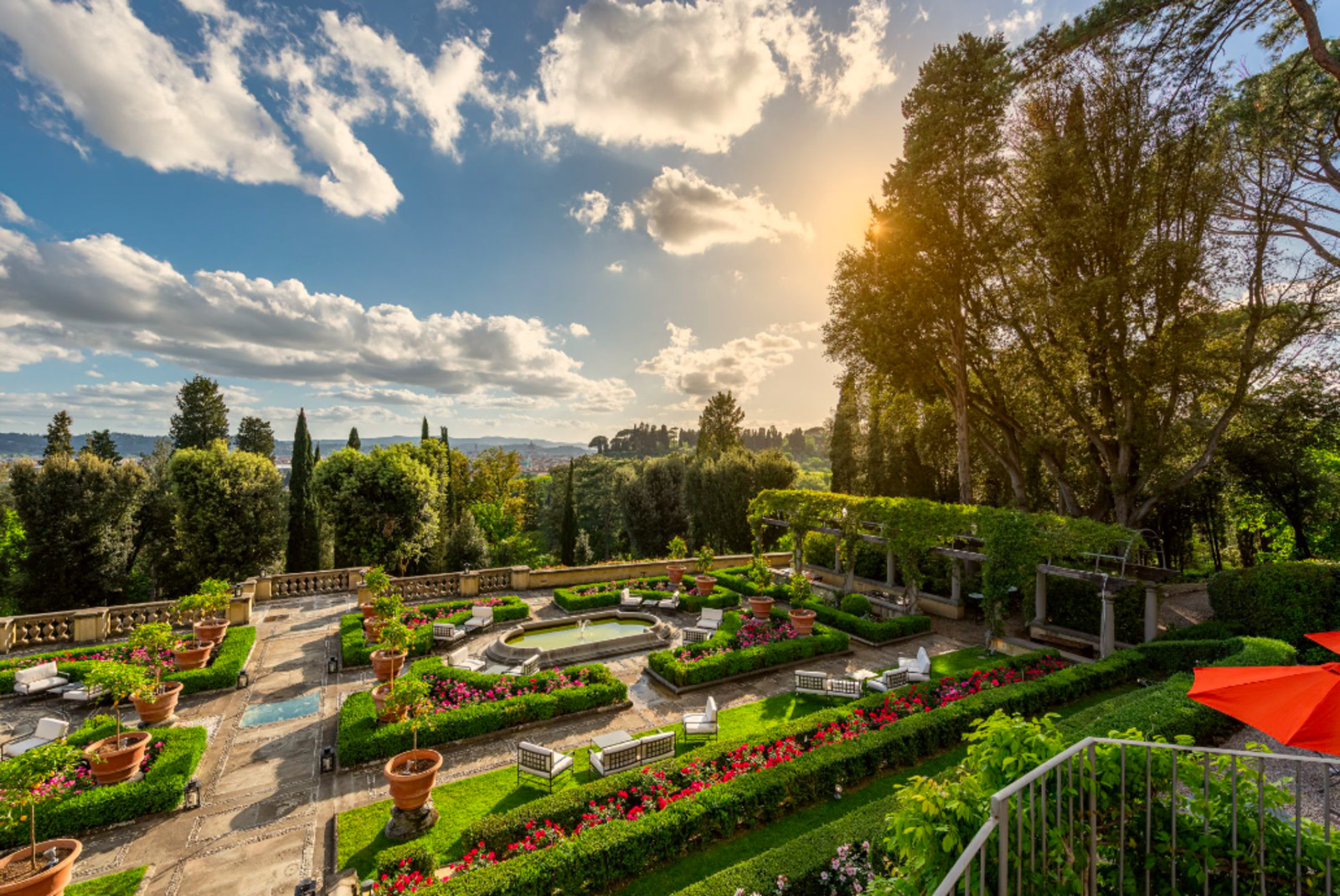 Gardens surrounded by trees with clouds in the sky during daytime