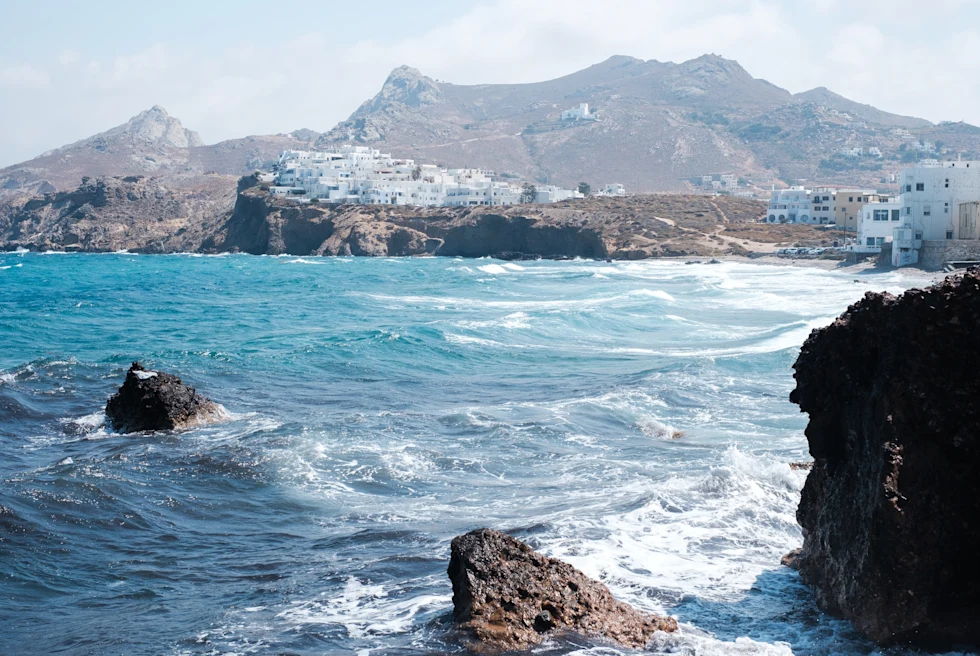 body of water with mountains and buildings in the background during daytime