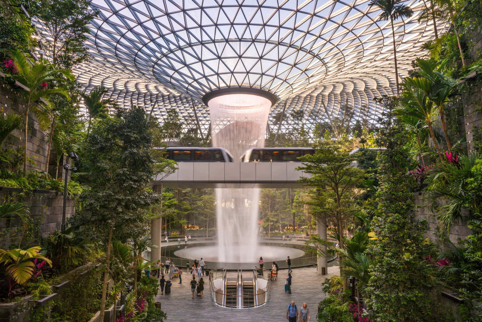 People standing next to indoor gardens and fountain