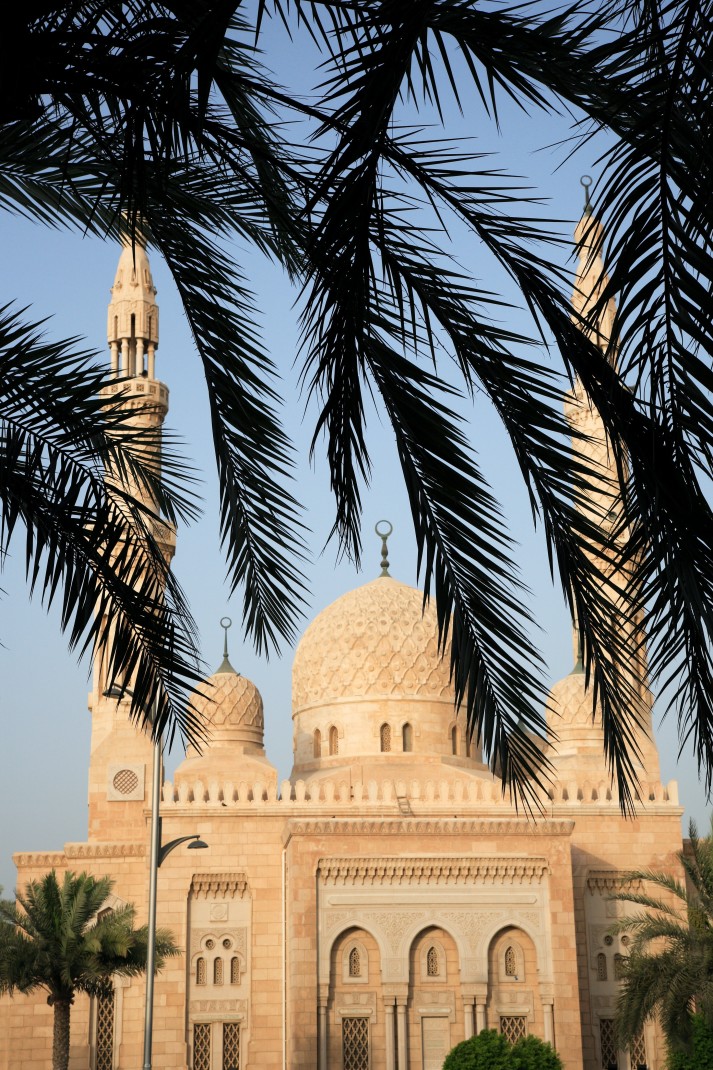 Jumeirah Mosque with trees in the foreground with a blue sky