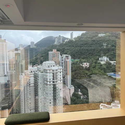 A view of Hong Kong's mountains and buildings from a hotel window.