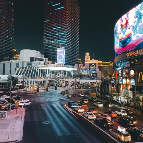 Street with cars lined with tall buildings during nighttime