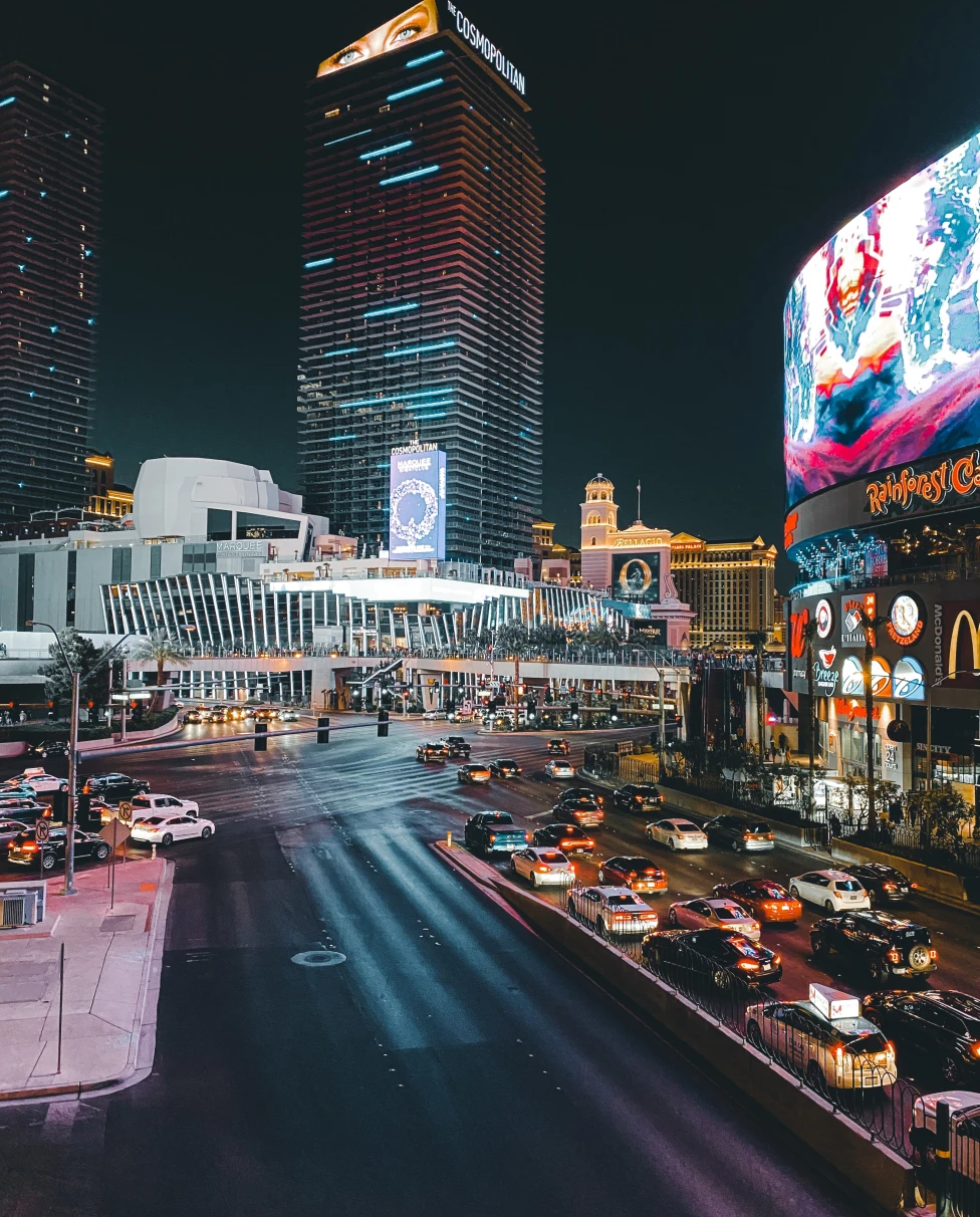 Street with cars lined with tall buildings during nighttime