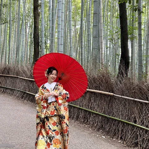 A woman in traditional Japanese dress holding a red umbrella. 