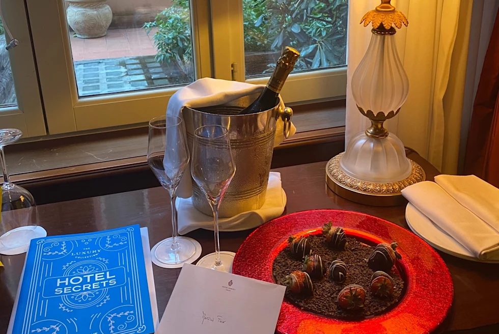 Table with chocolate covered strawberries and wine bottle.