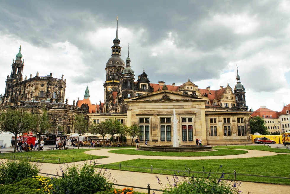 A huge historical building in Dresden with a fountain in front of it.