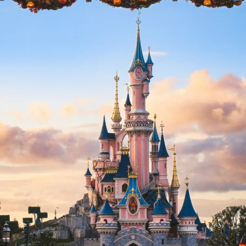 A pink and blue castle at Disneyland Paris during the daytime