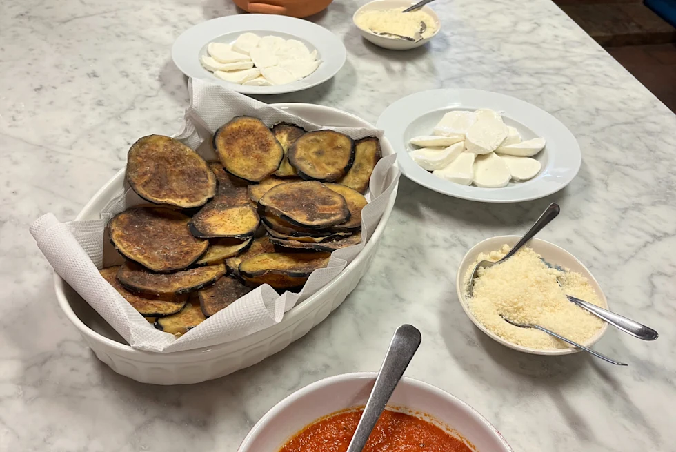 roasted eggplant slices and a red sauce on a marble counter