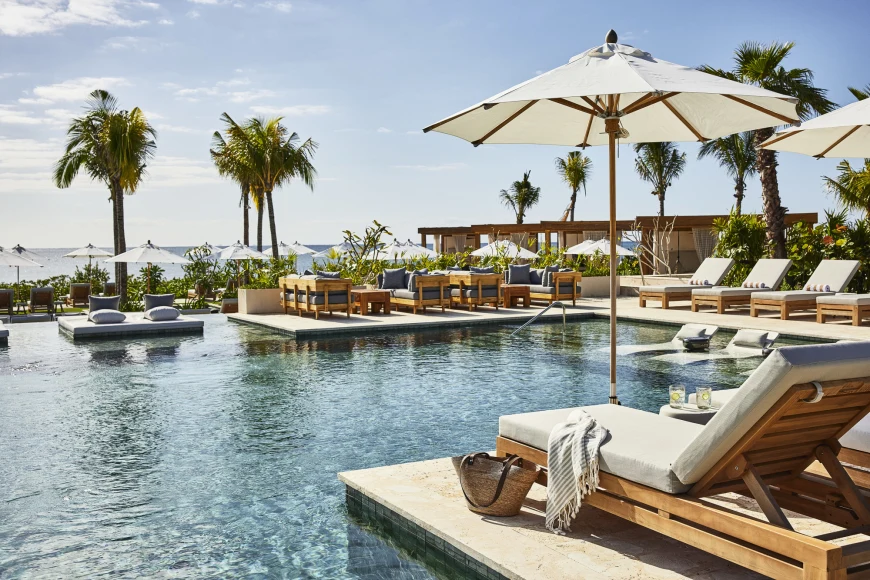 lounge chairs overlook an oceanfront pool