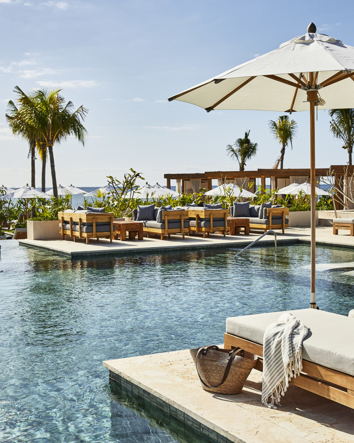 lounge chairs overlook an oceanfront pool