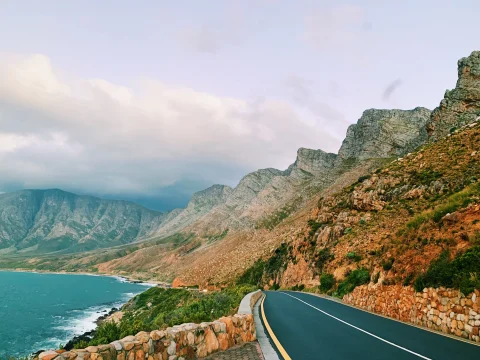Road running alongside the blue ocean and mountains in South Africa