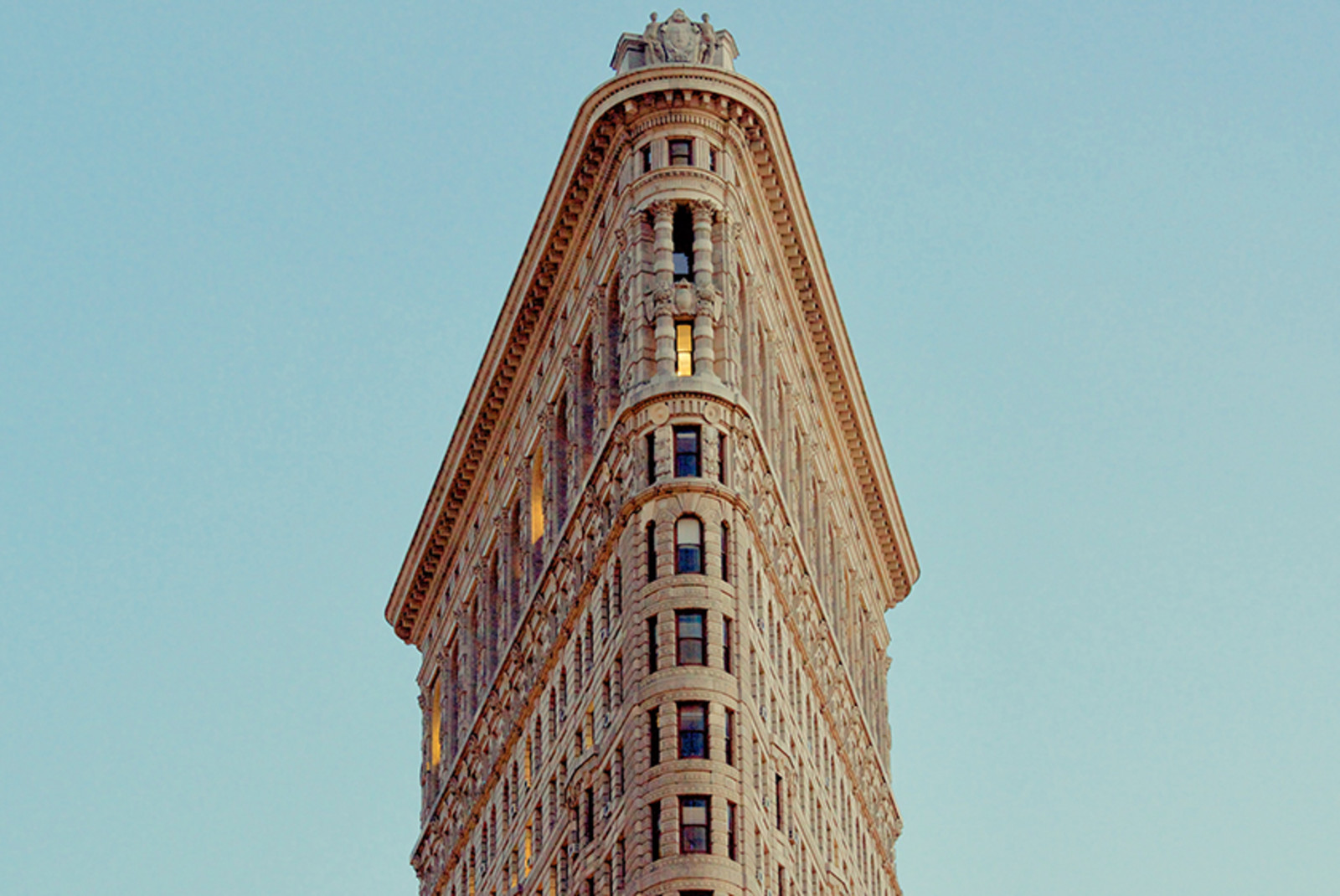 new york city the flatiron tan building in the blue sky with windows
