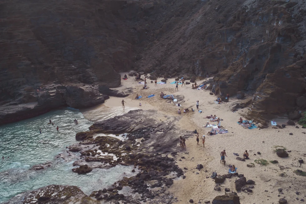 aerial view of people on a rocky beach during daytime