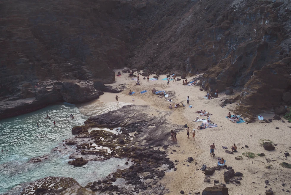 aerial view of people on a rocky beach during daytime