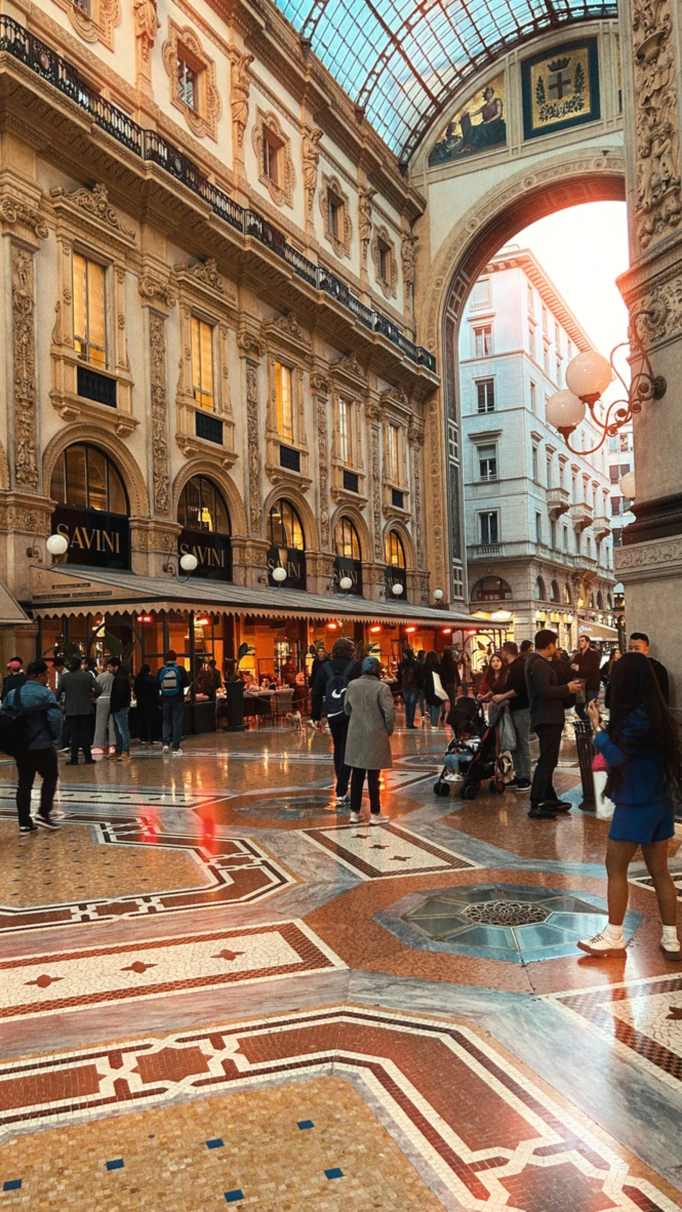 A picture of the interior of a European building with people walking around.