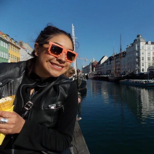 Travel Advisor Astrid Torres with orange sunglasses on in front of a canal.