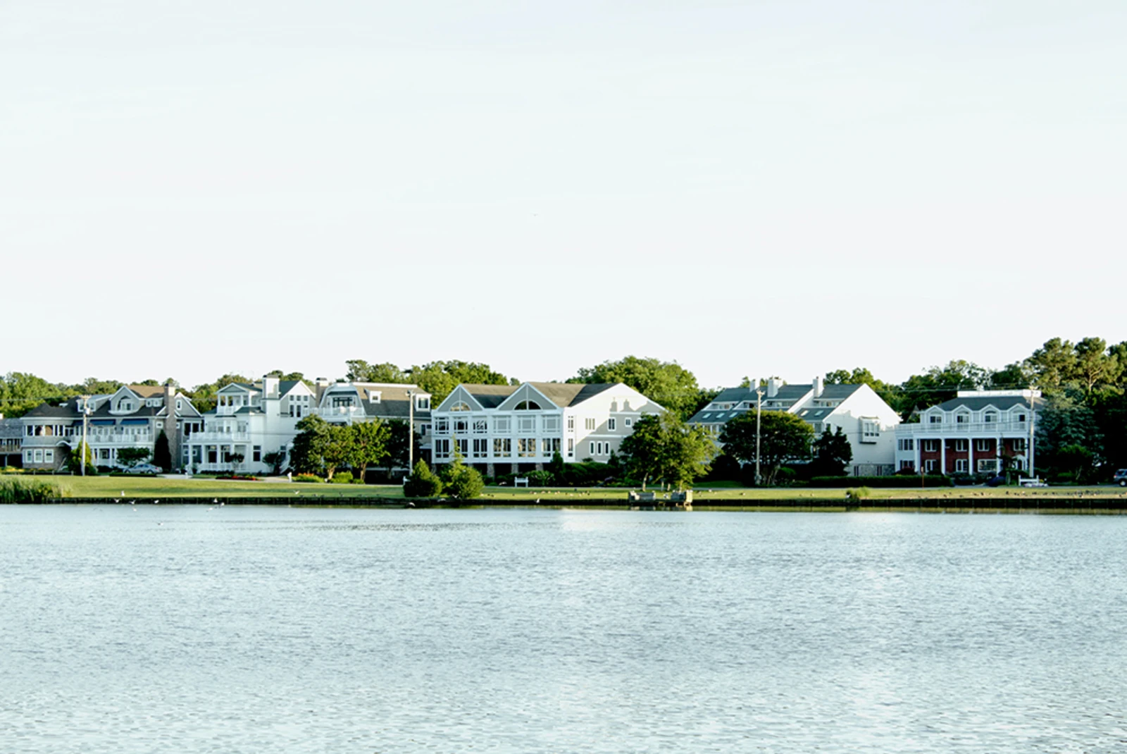 Large, white cottage homes along Rehoboth beach.