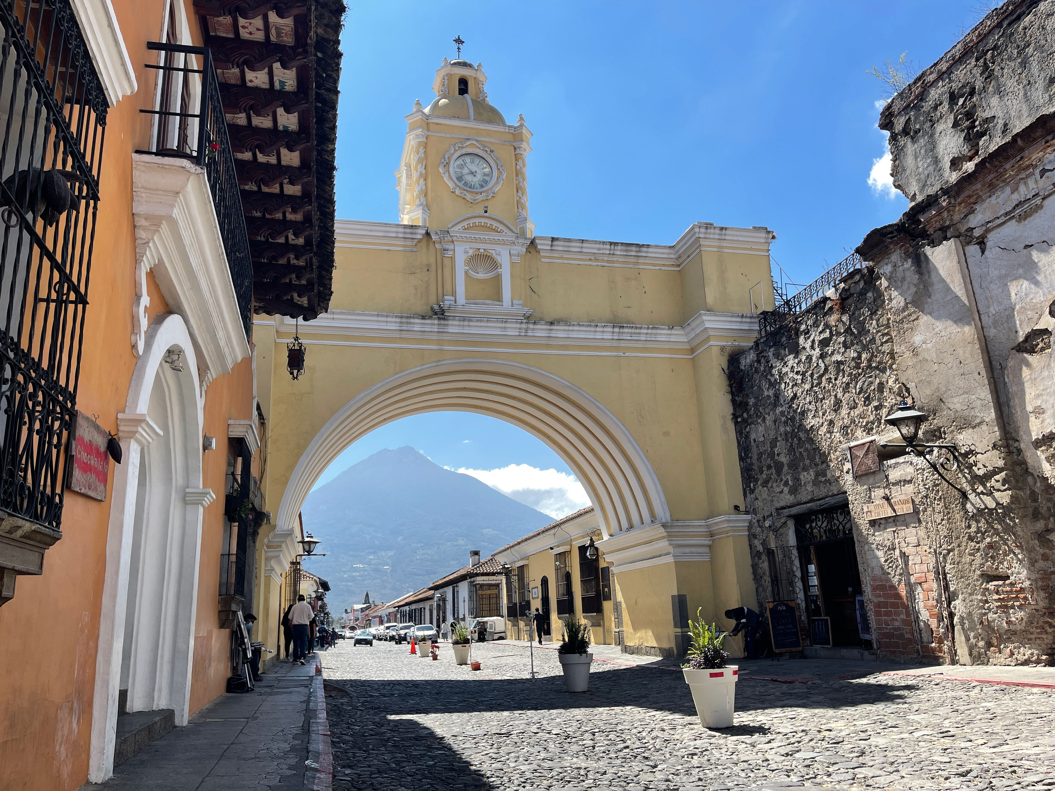 street with arch and green mountains in the near distance