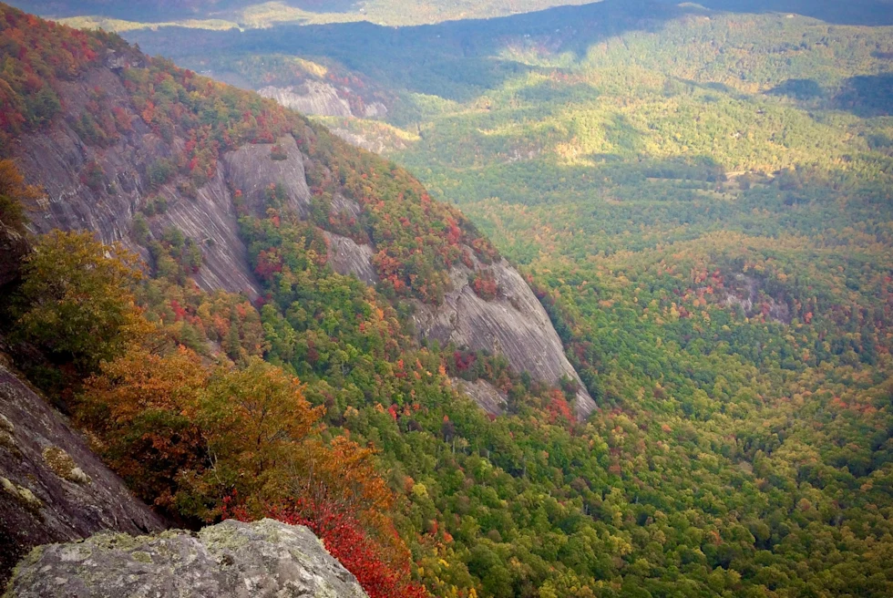 Fall foliage amongst yellow, red and orange in highlands valley from top of peak.
