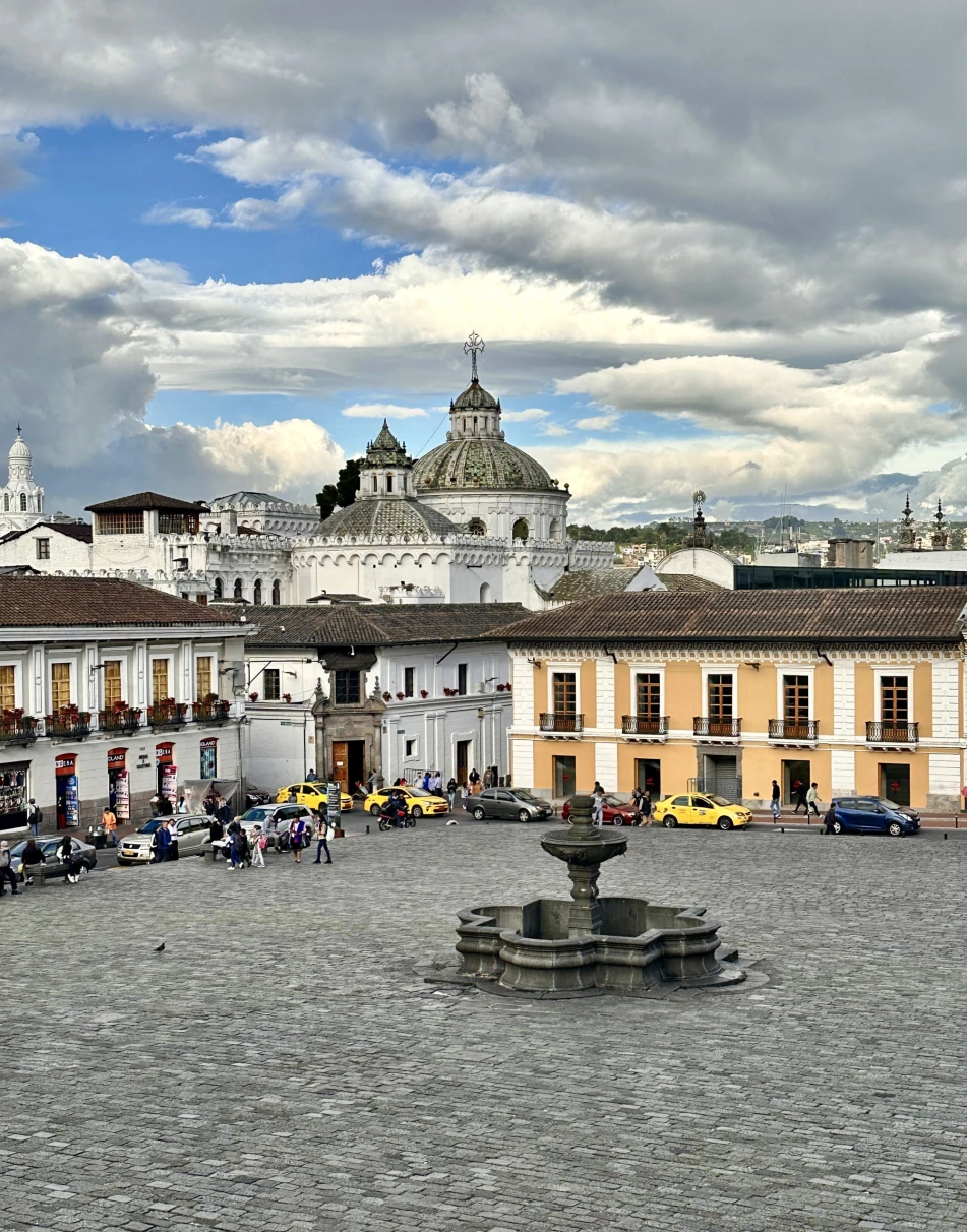 A fountain in a compound surrounded by buildings.