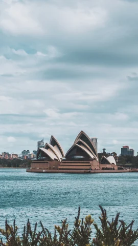 sydney harbor with cloudy skies during daytime