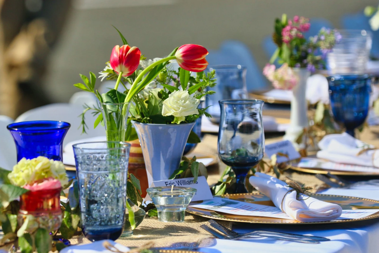 table set with flowers and blue glasses