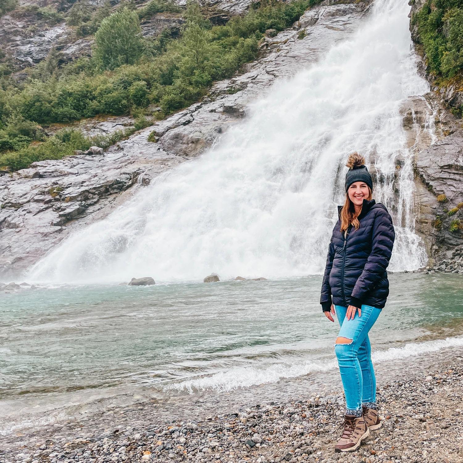 Travel advisor posing beside a waterfall