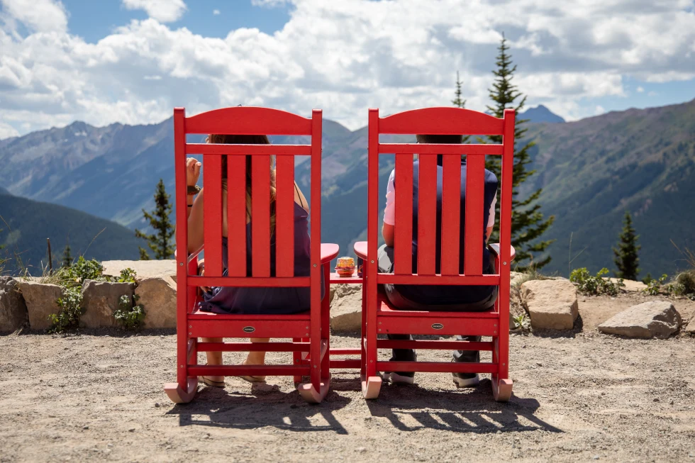Two red chairs on a mountain lookout point in Vail. 