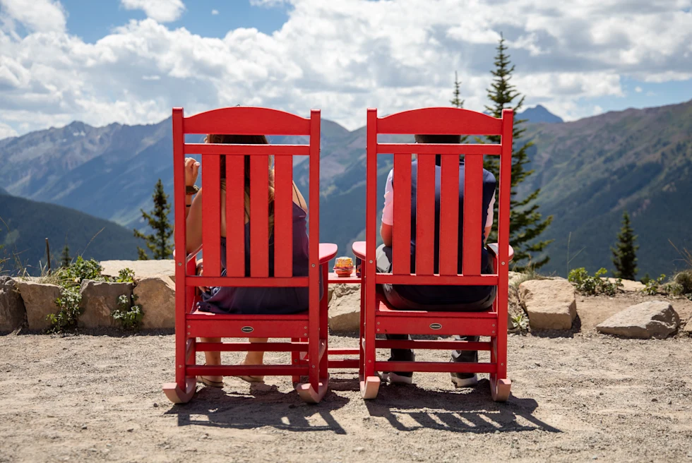 Two red chairs on a mountain lookout point in Vail.