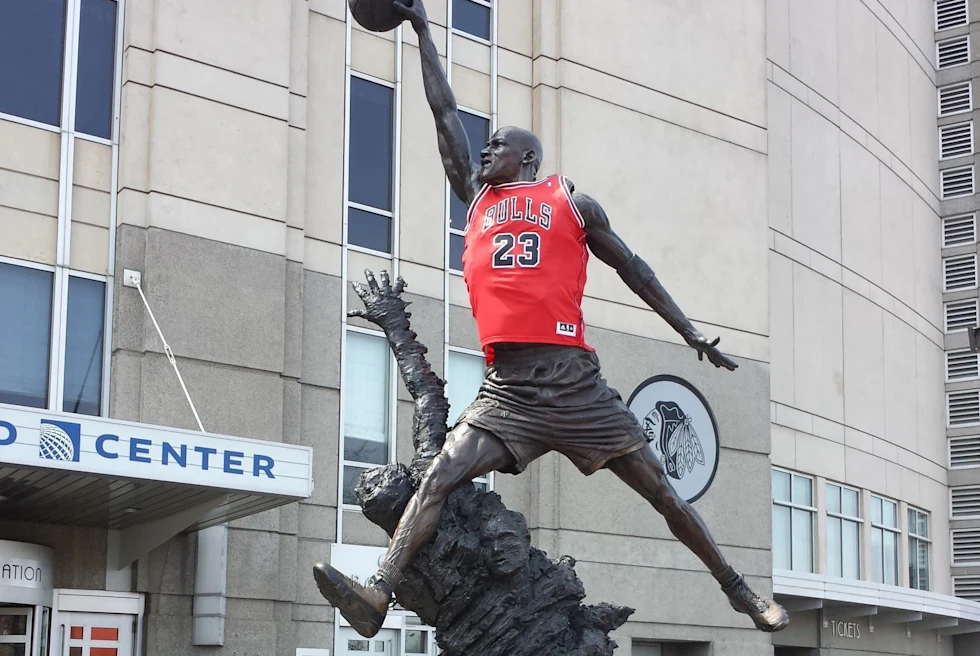 iron statue of Michael Jordan wearing a Chicago Bulls jersey in front of a stadium entrance