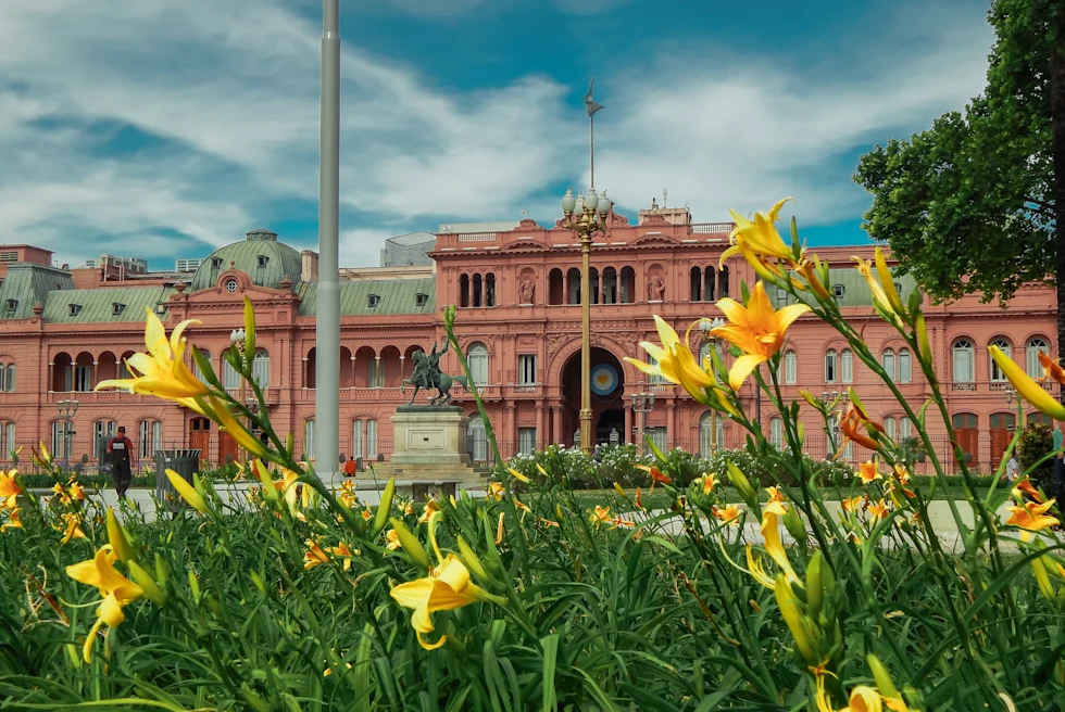 A vintage building with yellow-colored flowers in the front