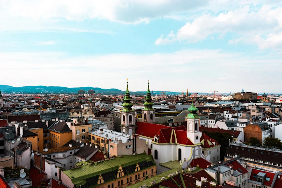 rooftops of historic city with varied architecture on a sunny day with clouds