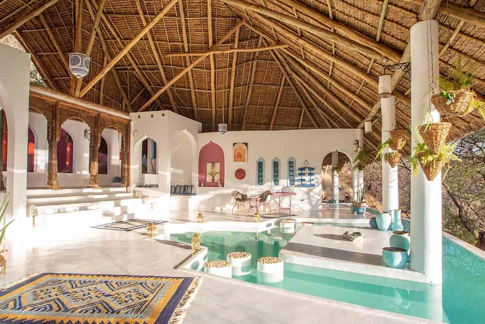 A balcony with pool, marble floor and jute roof.
