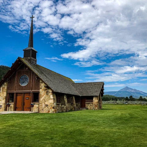 A hut with steeple in green mountains.