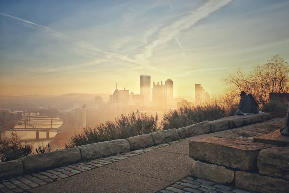 Stone walkway with green foliage and fog overlooking buildings