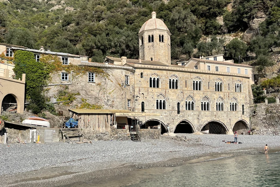 an old building on a calm rocky beach 