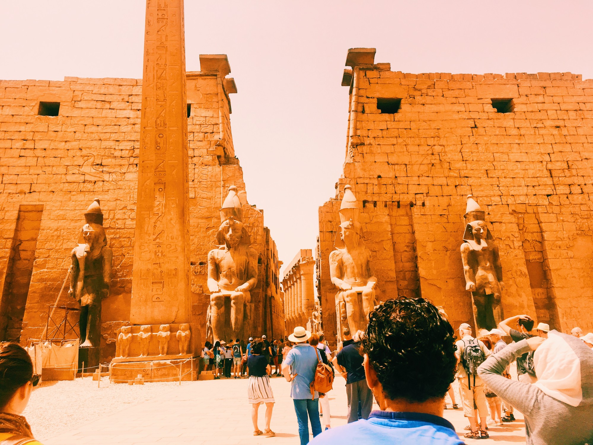ancient ruins in a desert with large sculptures at the entrance
