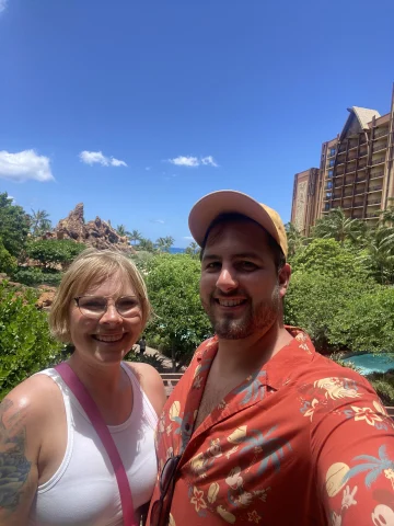 A couple posing in front of Disney's Aulani Resort.