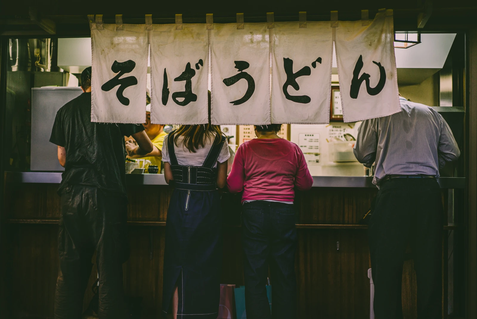 People eating at a food stand in Tokyo, Japan. 