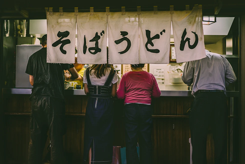 People eating at a food stand in Tokyo, Japan.